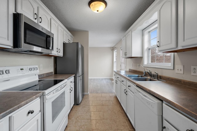 kitchen featuring white cabinetry, sink, a textured ceiling, and appliances with stainless steel finishes