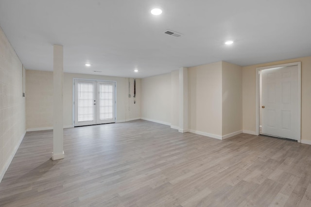 empty room featuring french doors and light hardwood / wood-style flooring