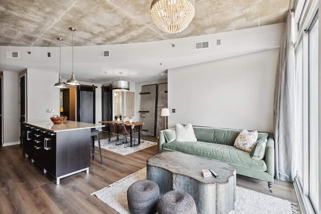 living room with dark hardwood / wood-style flooring and an inviting chandelier