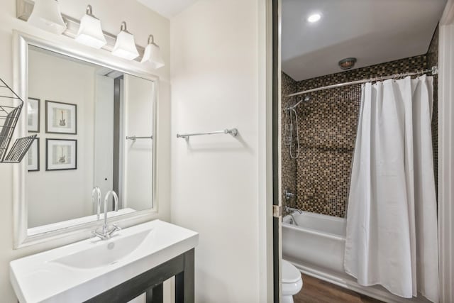 full bathroom featuring hardwood / wood-style floors, shower / tub combo, toilet, and sink