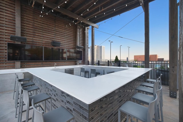 patio terrace at dusk featuring an outdoor bar