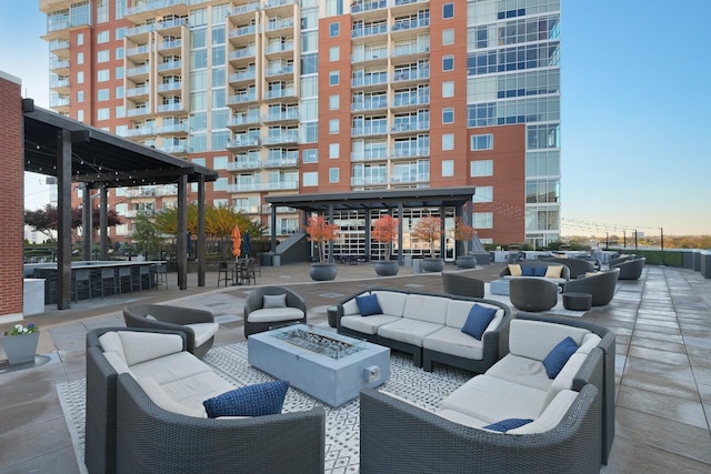 view of patio / terrace with an outdoor bar and an outdoor living space with a fire pit