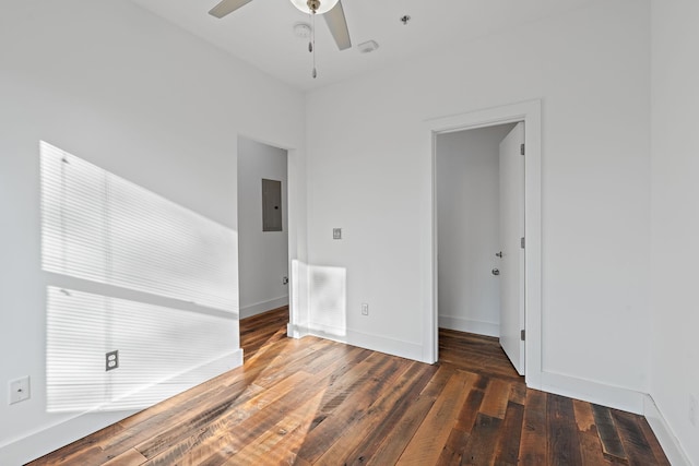 spare room with electric panel, ceiling fan, and dark wood-type flooring