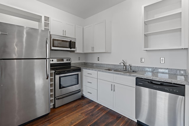 kitchen featuring appliances with stainless steel finishes, light stone counters, sink, dark hardwood / wood-style floors, and white cabinetry