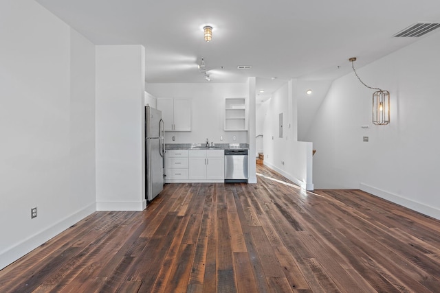 kitchen featuring pendant lighting, white cabinets, sink, dark hardwood / wood-style floors, and appliances with stainless steel finishes