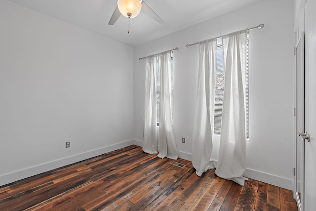 spare room featuring ceiling fan and dark wood-type flooring