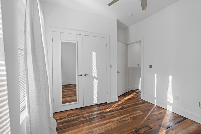 unfurnished bedroom featuring ceiling fan, dark hardwood / wood-style floors, and a closet