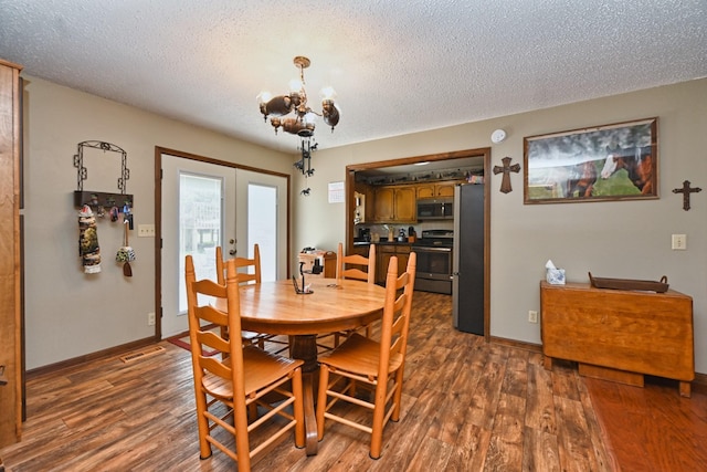 dining room with a notable chandelier, a textured ceiling, french doors, and dark hardwood / wood-style flooring