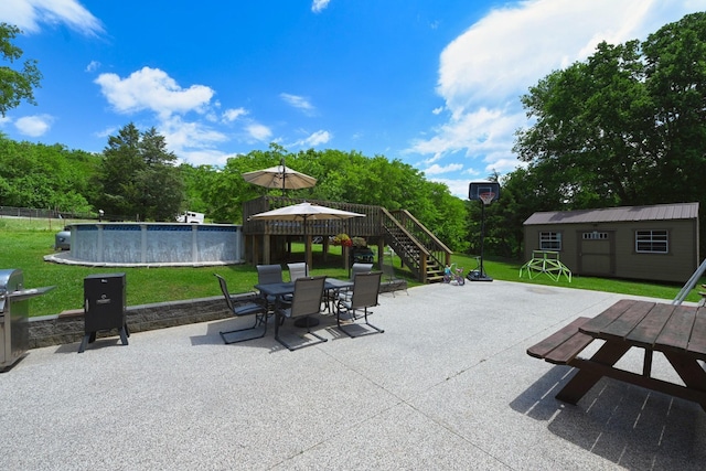 view of patio with a storage unit, a fenced in pool, and area for grilling