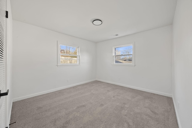 unfurnished room featuring plenty of natural light and light colored carpet