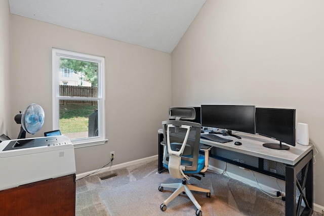 office space featuring carpet flooring, vaulted ceiling, and plenty of natural light