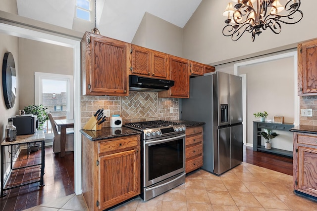 kitchen featuring a chandelier, a high ceiling, stainless steel appliances, and a healthy amount of sunlight