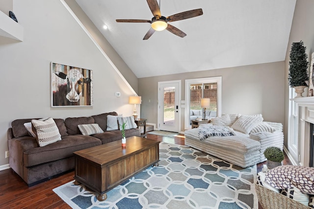 living room featuring ceiling fan, dark hardwood / wood-style floors, and vaulted ceiling