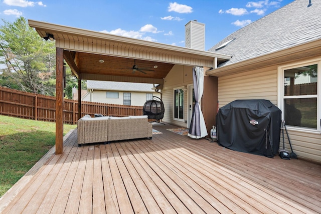 wooden terrace with grilling area, ceiling fan, and an outdoor hangout area