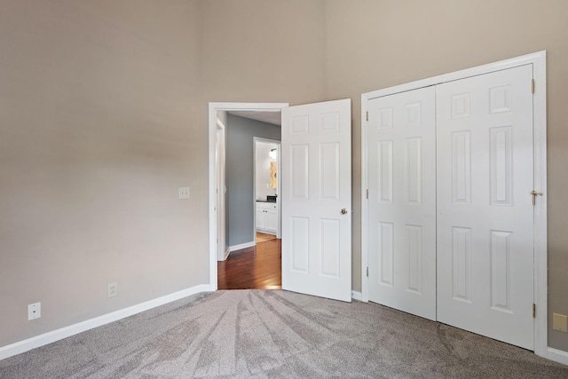 unfurnished bedroom featuring dark carpet and a closet