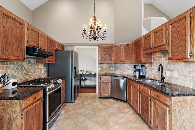 kitchen featuring stainless steel appliances, tasteful backsplash, high vaulted ceiling, a chandelier, and pendant lighting