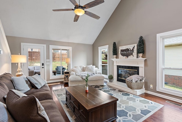 living room featuring hardwood / wood-style flooring, ceiling fan, and high vaulted ceiling