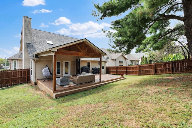 back of house featuring a lawn, an outdoor living space, and a deck