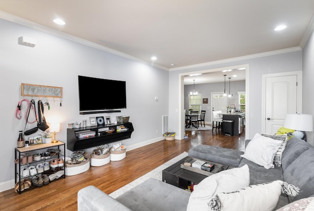 living room with sink, dark hardwood / wood-style flooring, a notable chandelier, and ornamental molding