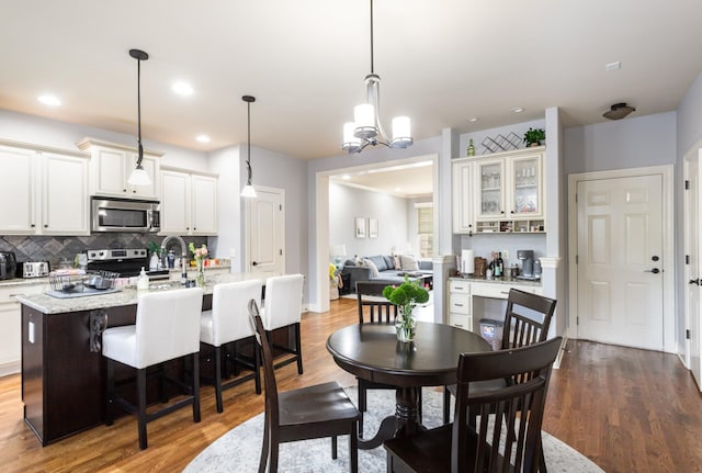 dining room featuring sink, a chandelier, and light hardwood / wood-style floors