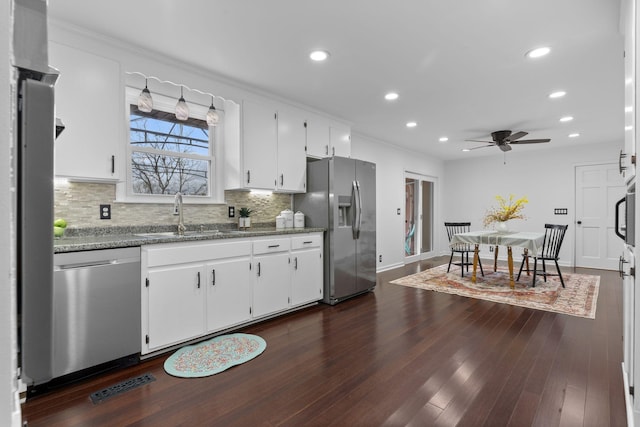 kitchen featuring white cabinets, stone countertops, stainless steel appliances, and sink