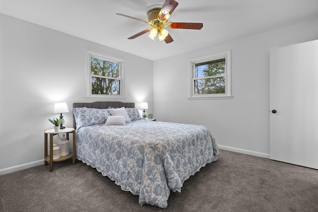 bedroom with dark colored carpet, ceiling fan, and multiple windows