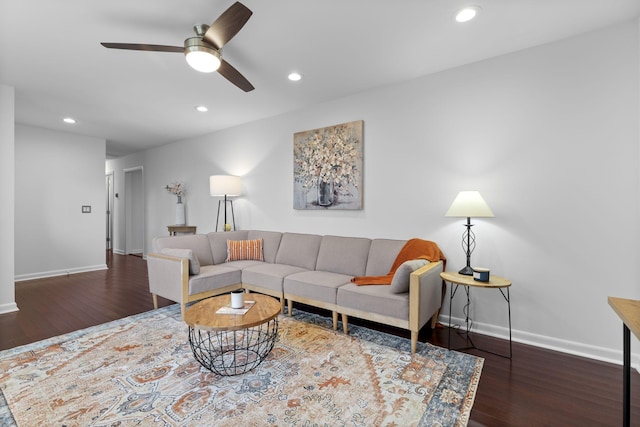 living room featuring ceiling fan and dark hardwood / wood-style flooring