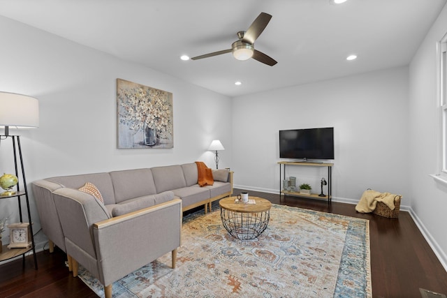 living room featuring ceiling fan and dark wood-type flooring