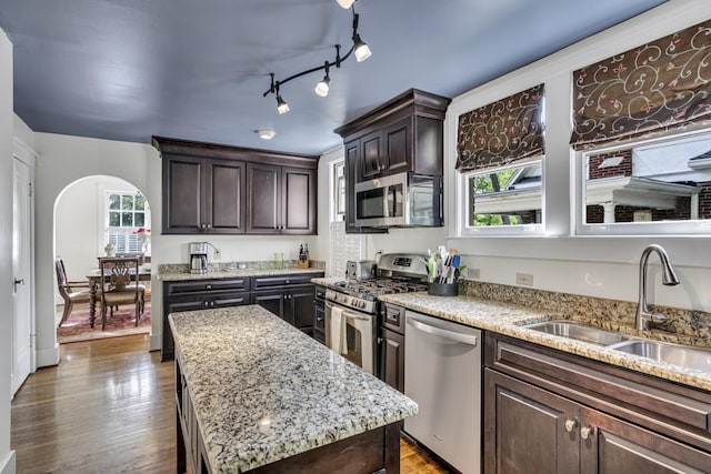 kitchen featuring dark brown cabinets, a center island, sink, and stainless steel appliances