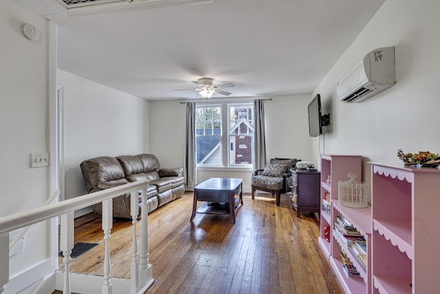 living room with a wall mounted AC, ceiling fan, and wood-type flooring