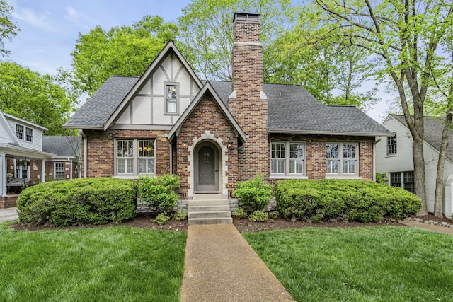 tudor home with a front lawn