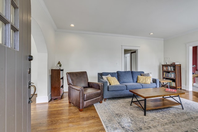 living room with light wood-type flooring and crown molding