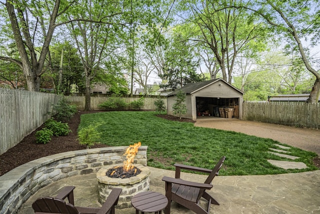 view of yard with an outbuilding, a patio, a fire pit, and a garage