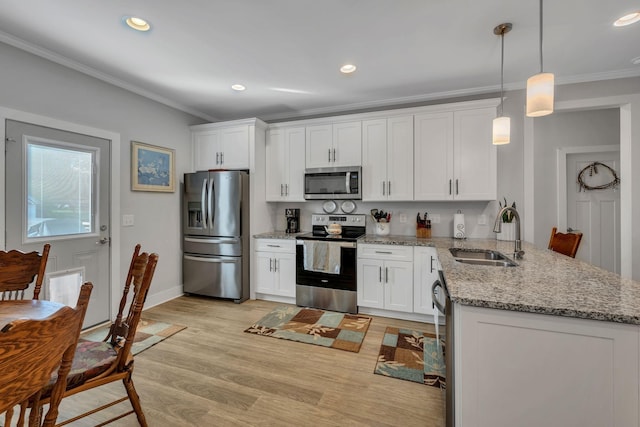 kitchen with white cabinets, appliances with stainless steel finishes, pendant lighting, and sink