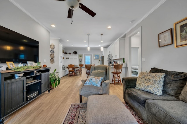 living room with ceiling fan, light hardwood / wood-style floors, and crown molding