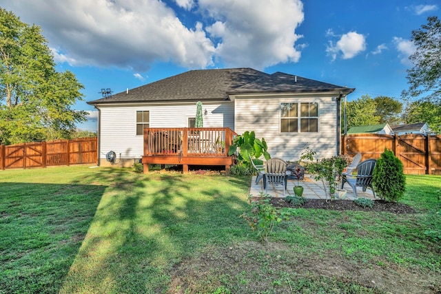 rear view of house with a yard, a patio, and a wooden deck