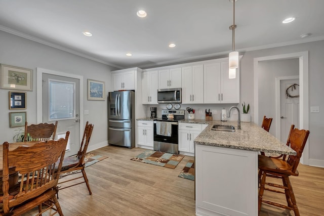 kitchen with white cabinetry, sink, hanging light fixtures, kitchen peninsula, and appliances with stainless steel finishes