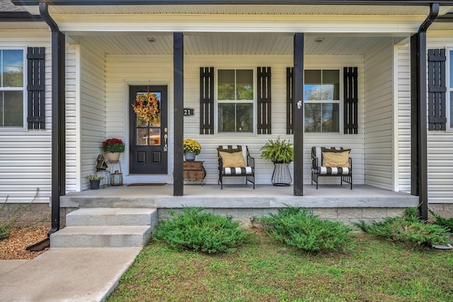 view of exterior entry featuring covered porch