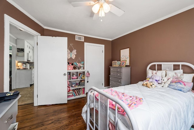 bedroom with ceiling fan, crown molding, and dark wood-type flooring