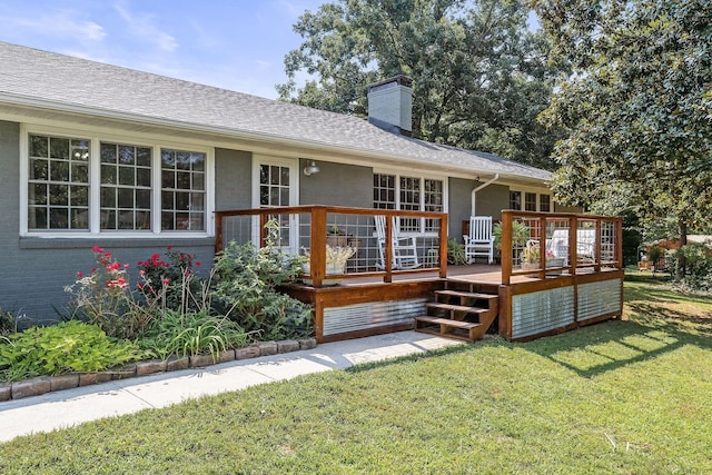 rear view of property with a yard and a deck