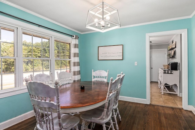 dining space with crown molding, dark hardwood / wood-style floors, and an inviting chandelier