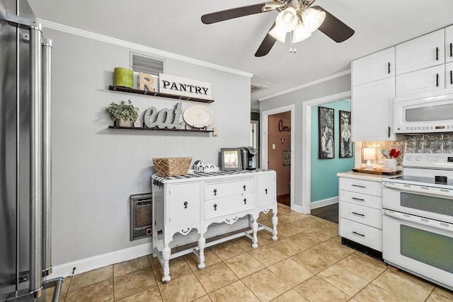 kitchen with stove, crown molding, light tile patterned floors, white cabinetry, and stainless steel refrigerator