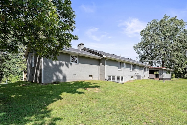 rear view of property featuring a lawn