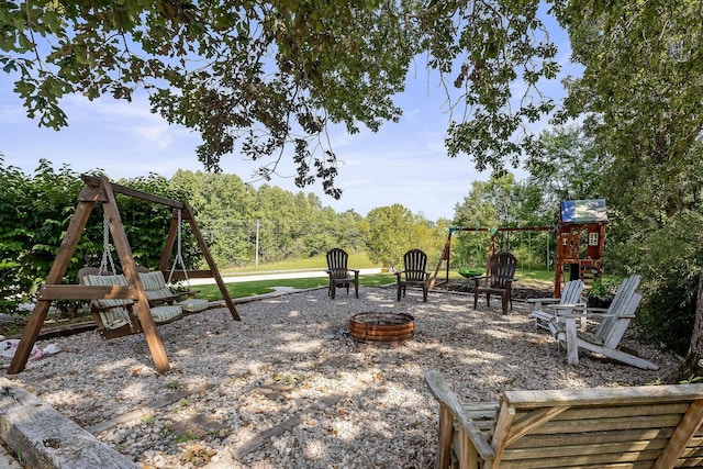 exterior space featuring a playground and a fire pit