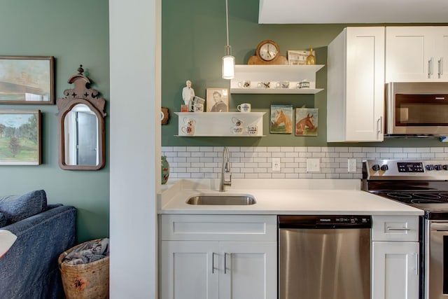 kitchen with sink, white cabinets, pendant lighting, and appliances with stainless steel finishes