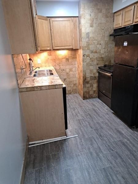 kitchen featuring stainless steel electric range, black fridge, sink, dark hardwood / wood-style floors, and light brown cabinetry