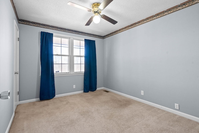 spare room featuring a ceiling fan, carpet flooring, a textured ceiling, and baseboards