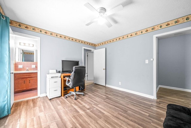 office space with light wood-style floors, baseboards, and a ceiling fan