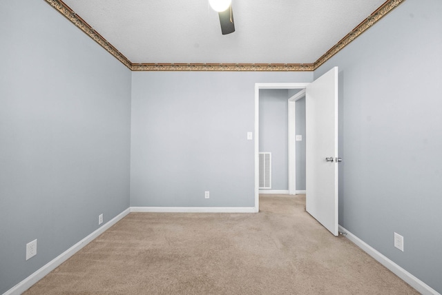 carpeted empty room featuring visible vents, baseboards, and a ceiling fan