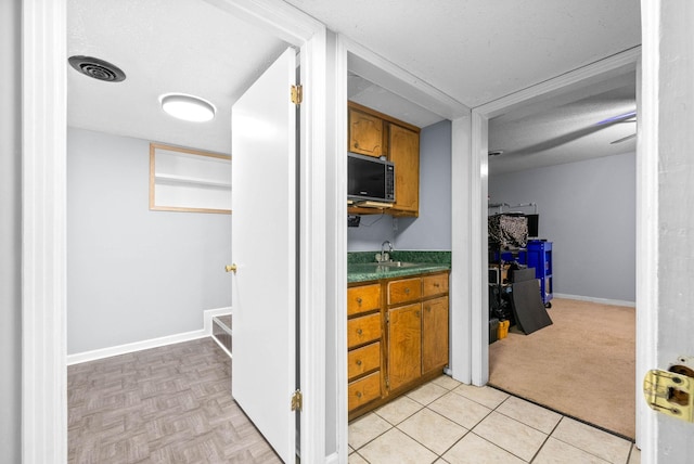 bathroom featuring visible vents, a textured ceiling, vanity, tile patterned flooring, and baseboards